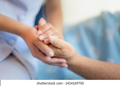 Nurse Sitting On A Hospital Bed Next To An Older Woman Helping Hands, Care. Elderly Patient Care And Health Lifestyle, Medical Concept.