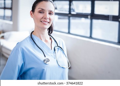 Nurse smiling at the camera in the hospital ward - Shutterstock ID 374641822