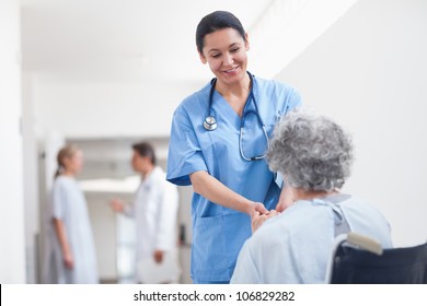 Nurse Standing Next To A Patient While Holding Her Hands In Hospital Ward