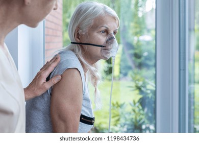 Nurse supporting sick senior woman with oxygen mask in the hospital - Powered by Shutterstock