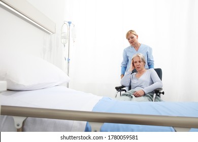 nurse take care elderly woman isolated on wheelchair near bed in hospital room, concept of loneliness and old age diseases