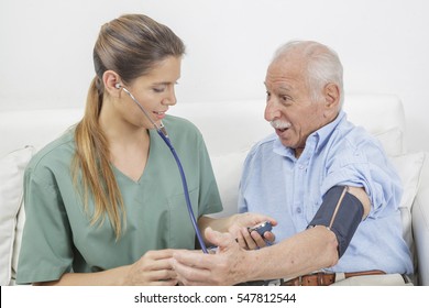 Nurse taking the blood pressure of elderly man
