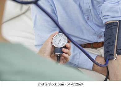 Nurse Taking The Blood Pressure Of Elderly Man