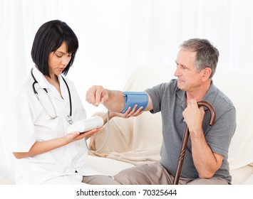 Nurse Taking Blood Pressure Of Her Patient