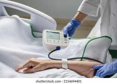 Nurse Taking Blood Pressure Of A Patient Who Is Ill In The Hospital.