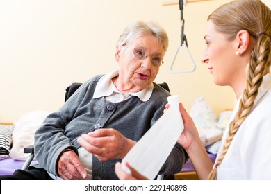 Nurse Taking Care Of Senior Woman In Retirement Home Bandaging A Wound