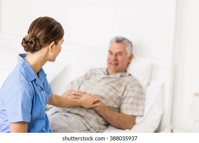 Nurse taking care of suffering senior patient at home - Powered by Shutterstock