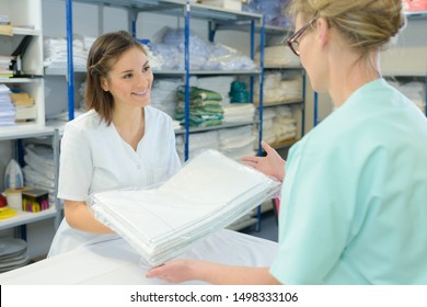 Nurse Taking Clean Sheets From Hospital Laundry