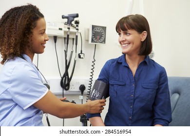 Nurse Taking Female Patient's Blood Pressure In Hospital