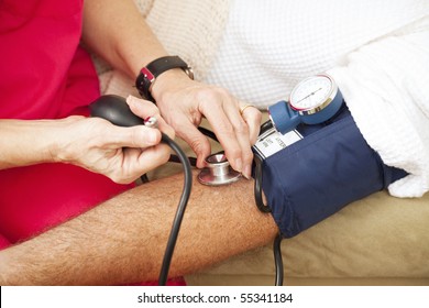 Nurse Taking A Patient's Blood Pressure Using A Sphygmomanometer.  Closeup View.