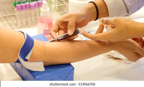 Nurse taking Real Blood samples (Phlebotomist) for analysis from a patient (Selective focus)