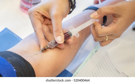 Nurse taking Real Blood samples (Phlebotomist) for analysis from a patient (Selective focus)