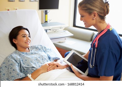 Nurse Talking To Female Patient On Ward Using Digital Tablet