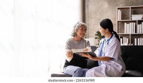 Nurse talking with a nursing home patient about his health. The nurse is making notes on a digital tablet - Powered by Shutterstock