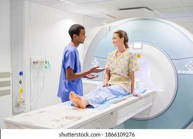 A nurse talking to a patient at the MRI scan machine in the hospital