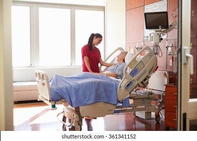 Nurse Talking To Senior Female Patient In Hospital Bed