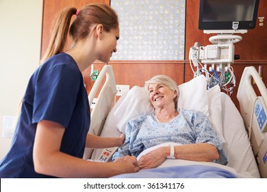 Nurse Talking To Senior Female Patient In Hospital Bed