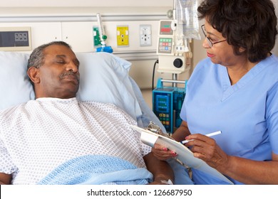 Nurse Talking To Senior Male Patient On Ward