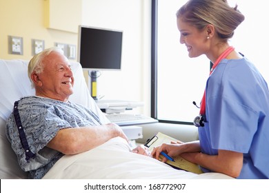 Nurse Talking To Senior Male Patient In Hospital Room