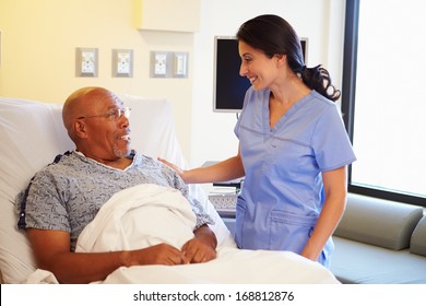 Nurse Talking To Senior Male Patient In Hospital Room