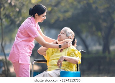 Nurse talking to senior woman  patient on wheelchair with a neck brace at park. - Powered by Shutterstock