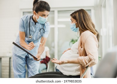 Nurse talking to worried pregnant woman and analyzing medical report before covid-19 vaccine at hospital waiting room. - Powered by Shutterstock