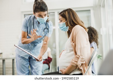 Nurse talking to young pregnant woman and analyzing medical report before before vaccination against coronavirus.
