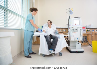 Nurse Tending To Male Patient About To Start Kidney Dialysis