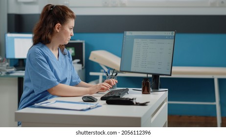 Nurse Typing On Computer Keyboard For Consultation And Appointment. Medical Assistant Using Technology For Healthcare System In Doctors Office. Specialist Working With Medical Equipment