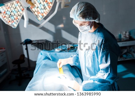 nurse in uniform and latex gloves putting on strip in operating room