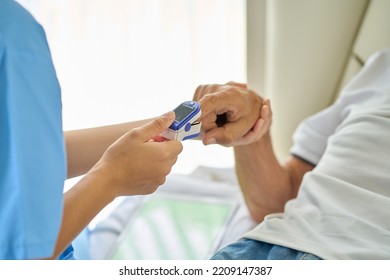 Nurse Use Pulse Oximeter To Check Patient's Oxygen In Home Bed Room , Home Healthcare Service Concept.