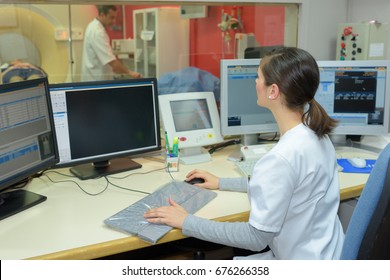 Nurse Using Computer At Reception Desk In Hospital