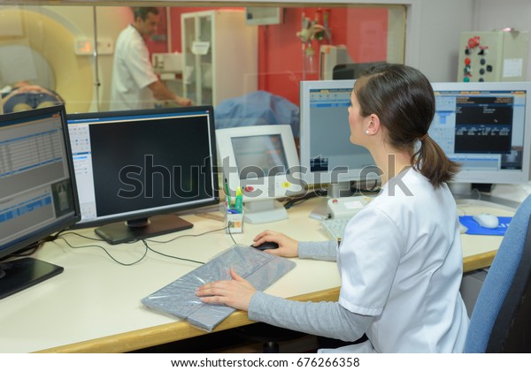 nurse using\
computer at reception desk in\
hospital