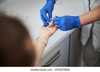 Nurse using a finger prick method for a hematological test