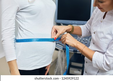 nurse using the ribbon to measure the size of a belly. close up side view cropped photo. - Powered by Shutterstock