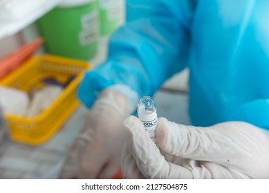 A Nurse Wearing Gloves Holds A Freshly Broken Ampule Of Tramadol HCL. Preparing To Inject Opioid Pain Medication. At The Hospital Or ER.