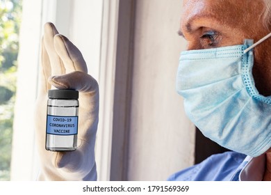 Nurse Wearing Surgical Mask And Gloves Holding Coronavirus COVID-19 Vaccine Vial. The Concept Of A Coronavirus Trial Vaccine Is In The Hands Of Scientists Wearing Medical Mask