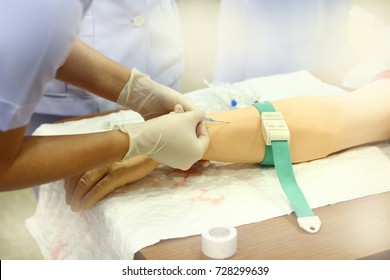Nurse Wears Gloves Training Injection With Arm Model For Education At Hospital Or School Of Nursing
