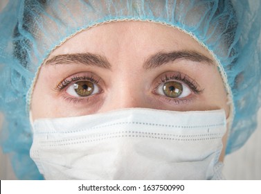 
Nurse In A White Mask. The Face Is Close. Tired Sad Eyes Of A Paramedic After A Hard Day's Work. 
Crossed Eyes. 
Coronavirus