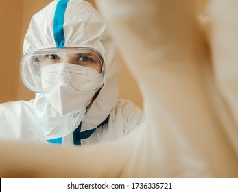 Nurse In A White Suit, Personal Protective Equipment, Glasses And A Mask Takes A Selfie Or Asks Her Correspondents Not To Take It Off.