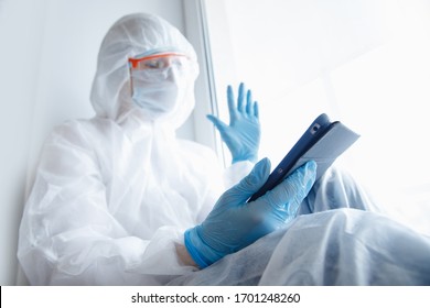 Nurse Woman In Quarantine Zone Of Hospital Calls Video Chat Online To Family, Coronavirus Pandemic. Web Connection Concept.