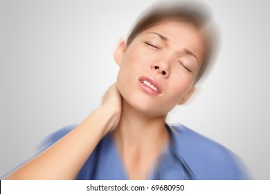 Nurse Or Young Woman Doctor Having Neck And Back Pain Problems At Work. Mixed-race Asian / Caucasian Female Model.