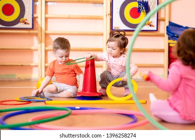 Nursery babies toddlers group play with rings in gym
