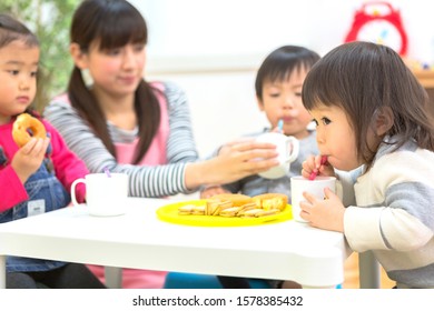 Nursery School Teacher And Snack Time