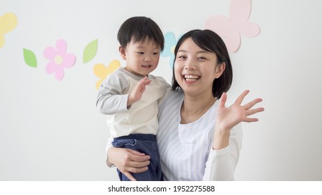 Nursery Teacher And Child Waving