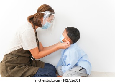 Nursery Teacher Putting A Mask To Children