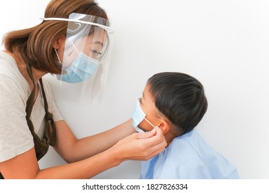 Nursery Teacher Putting A Mask To Children