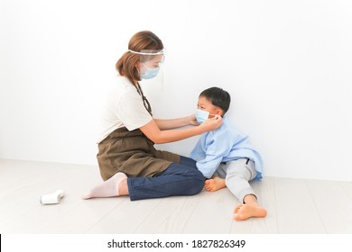 Nursery Teacher Putting A Mask To Children