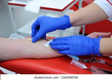 Nurse's Hands Taking Blood From The Vain Of A Donor - Hypodermic Needle, Tubes, Container With Blood