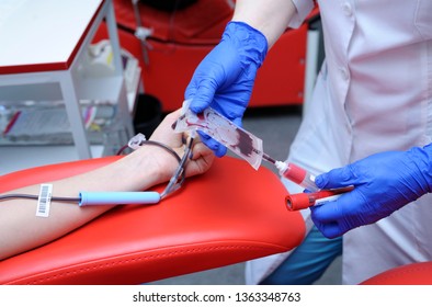 Nurse's Hands Taking Blood From The Vain Of A Donor - Hypodermic Needle, Tubes, Container With Blood